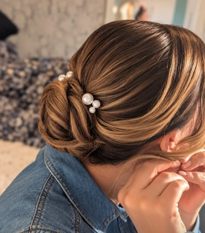 Pearl pins nestled into a softly sculpted brunette low bun by Becky.