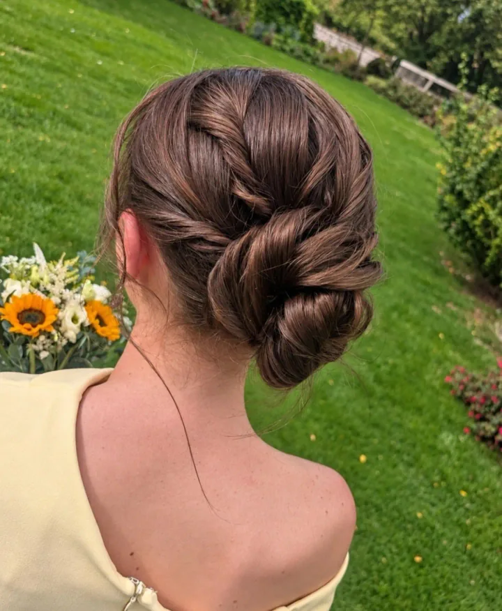 Textured detail in a low bun created by Becky